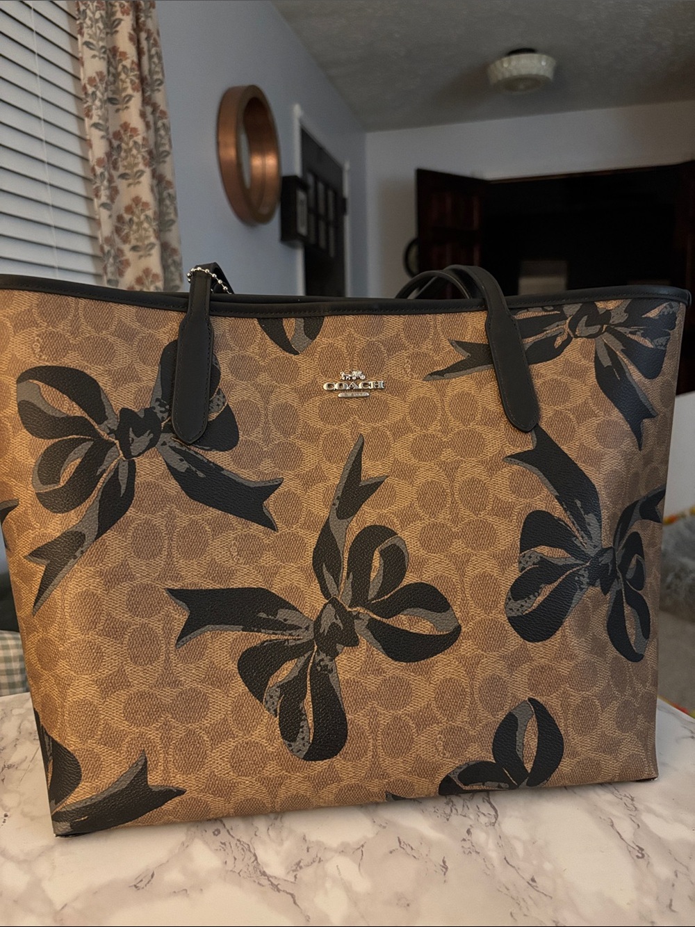 Gently used Coach Brown Signature Tote with Black Floral Bows